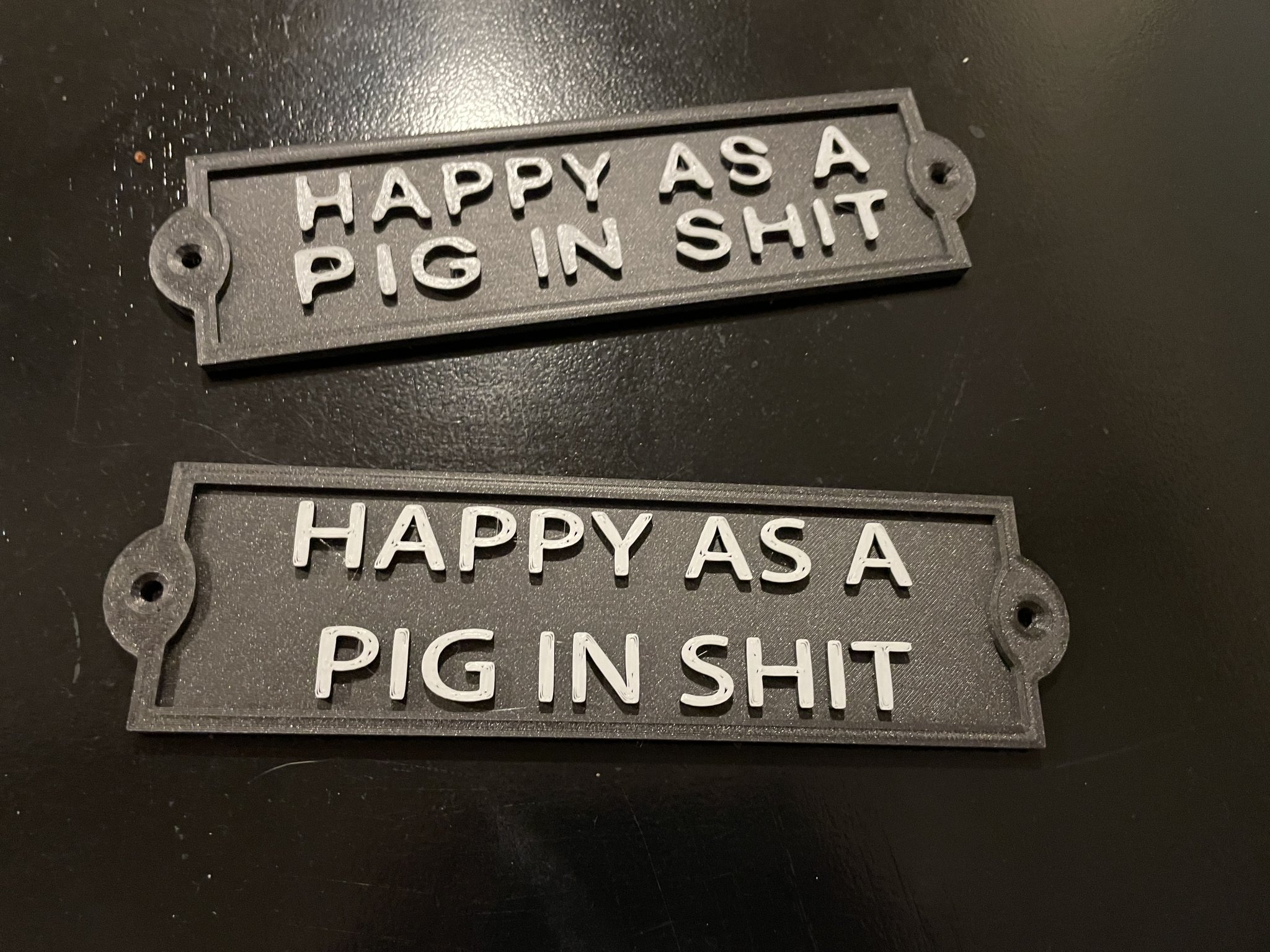 Biển hiệu "HAPPY AS A PIG IN SHIT" cho bàn làm việc