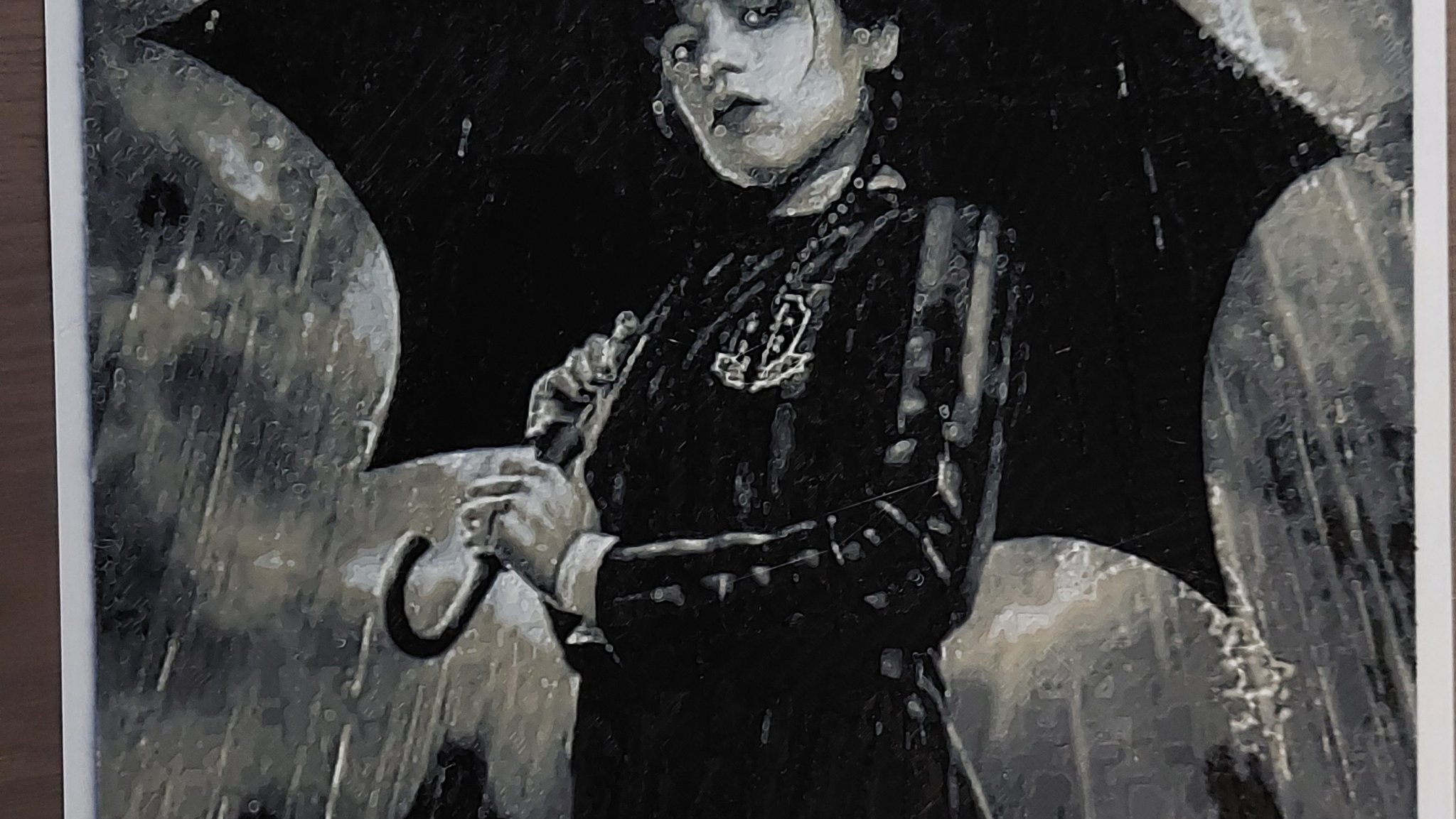 Nhân vật Wednesday Adams cầm ô trong mưa