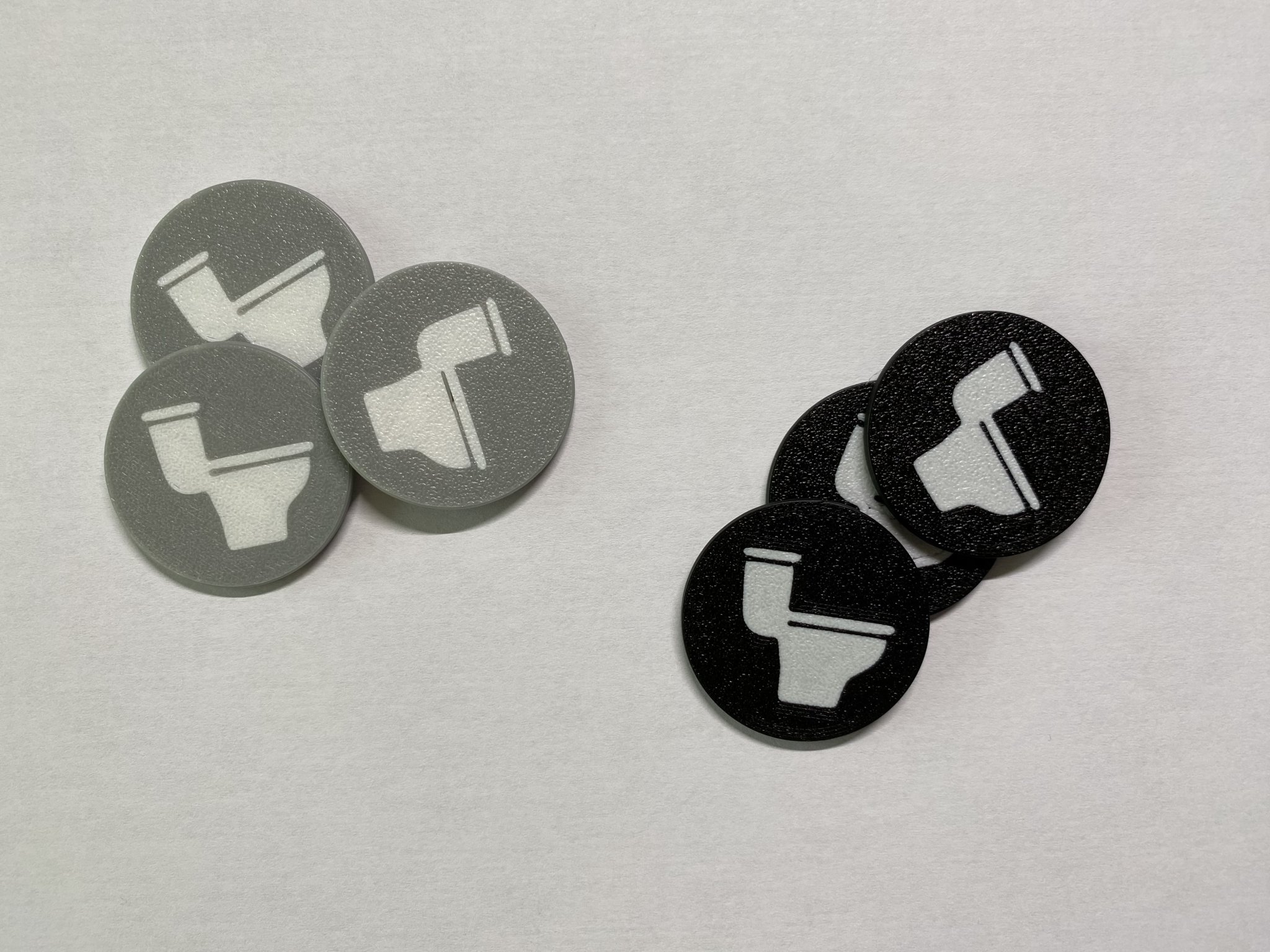 Token vệ sinh hai màu với biểu tượng nhà vệ sinh