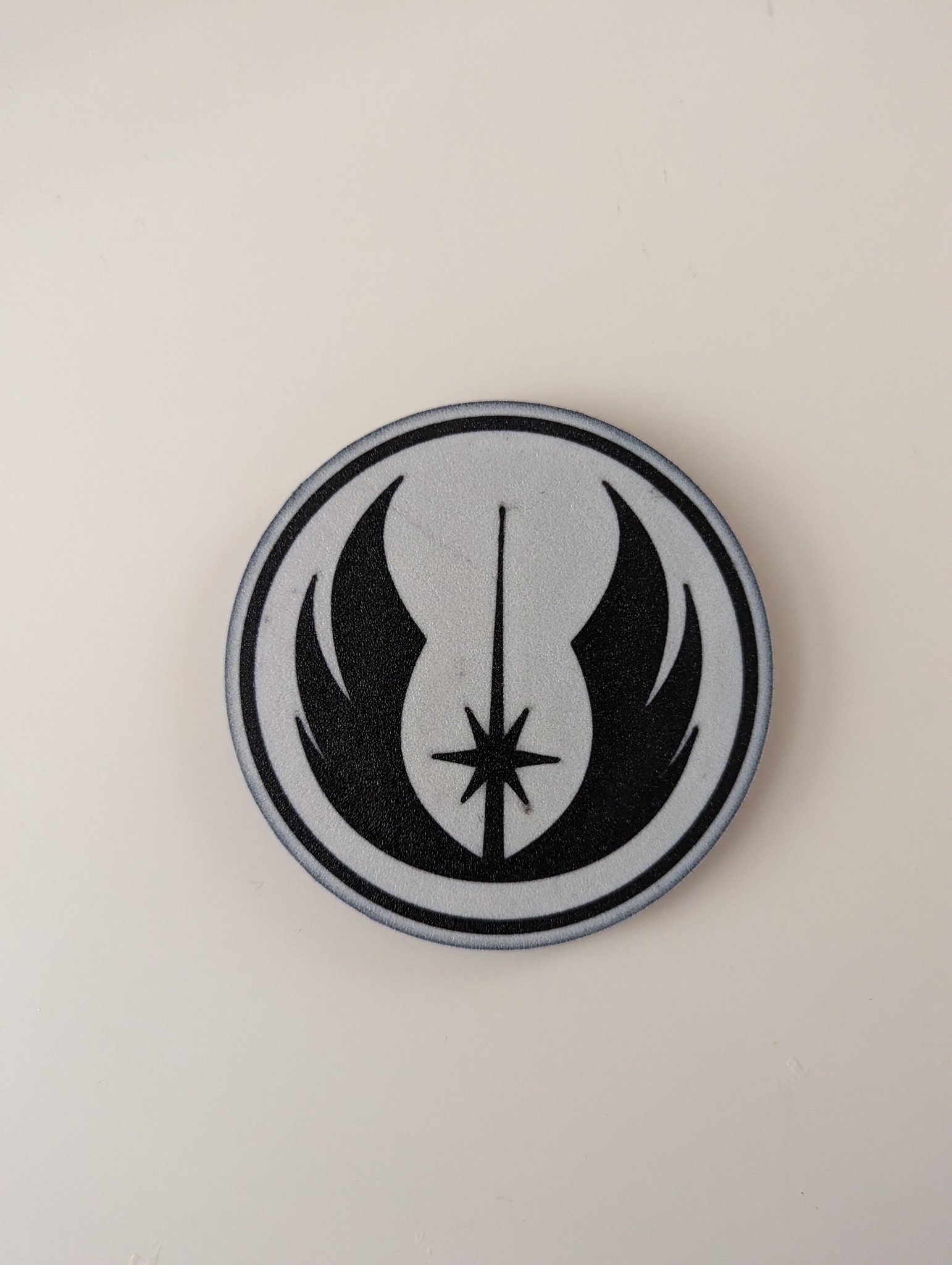 Đế lót ly đa màu sắc với logo Jedi Order trong Star Wars