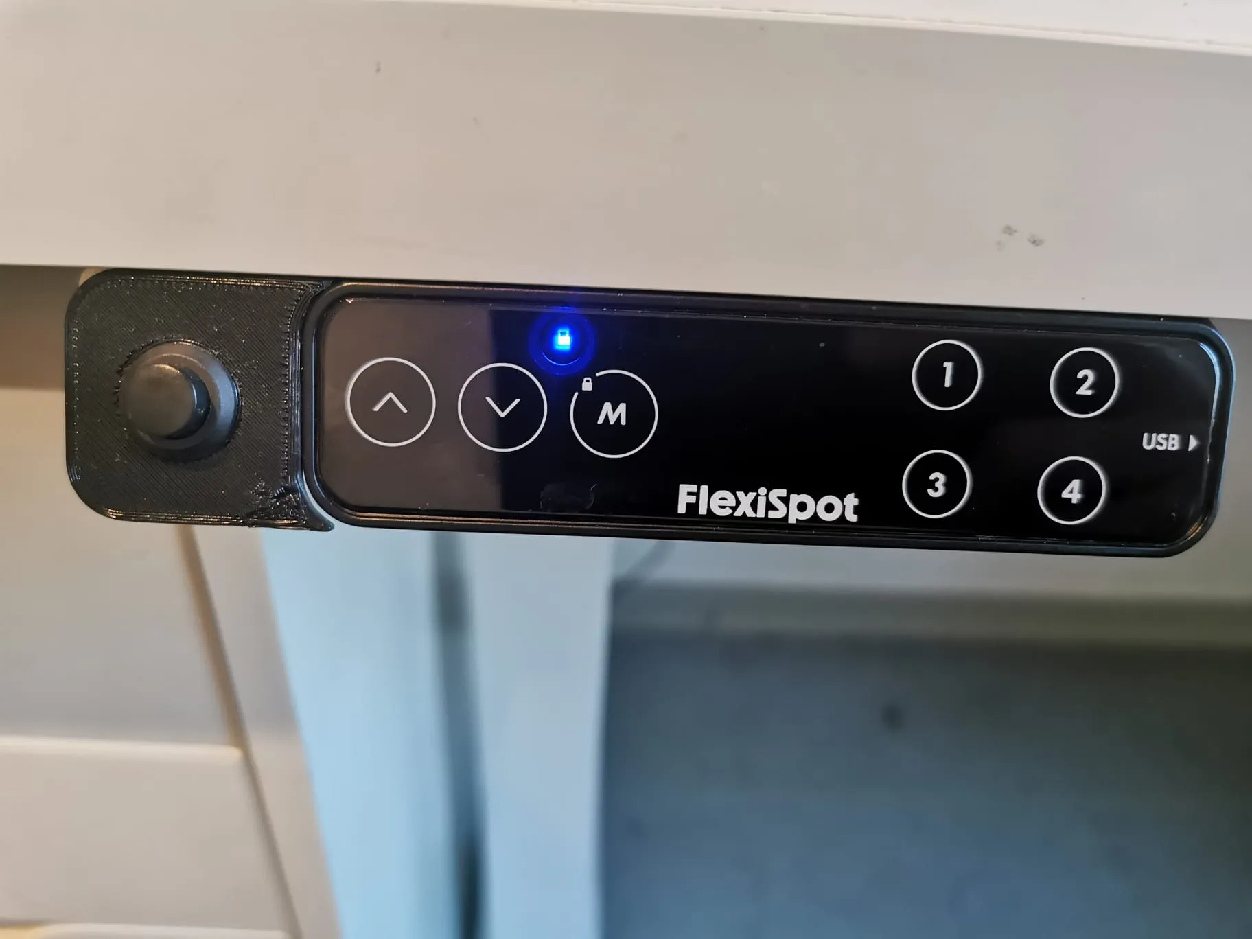 Công tắc điều khiển nguồn PC bên cạnh bảng FlexiSpot