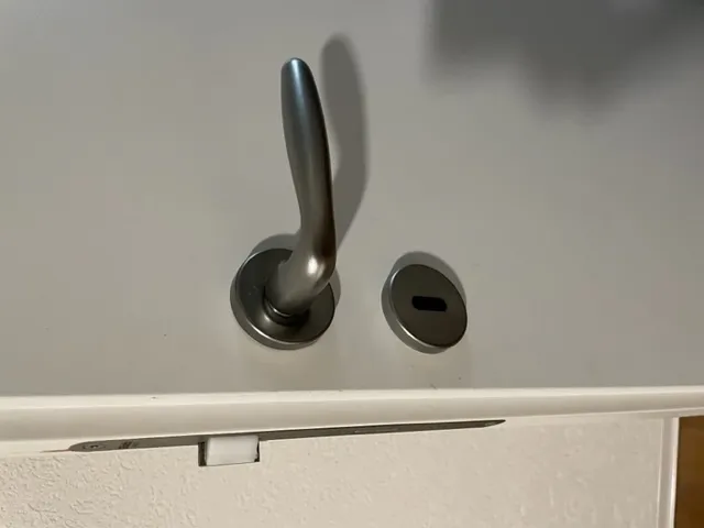 Phụ kiện nhựa dưới rosette cửa bị hỏng cần thay thế