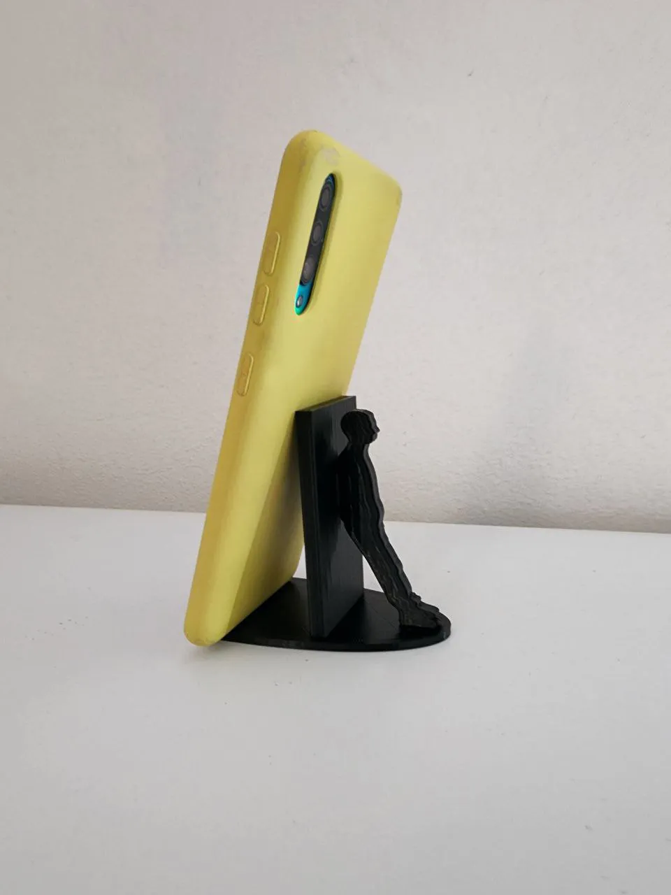 Giá đỡ điện thoại hình người dựa vào tường