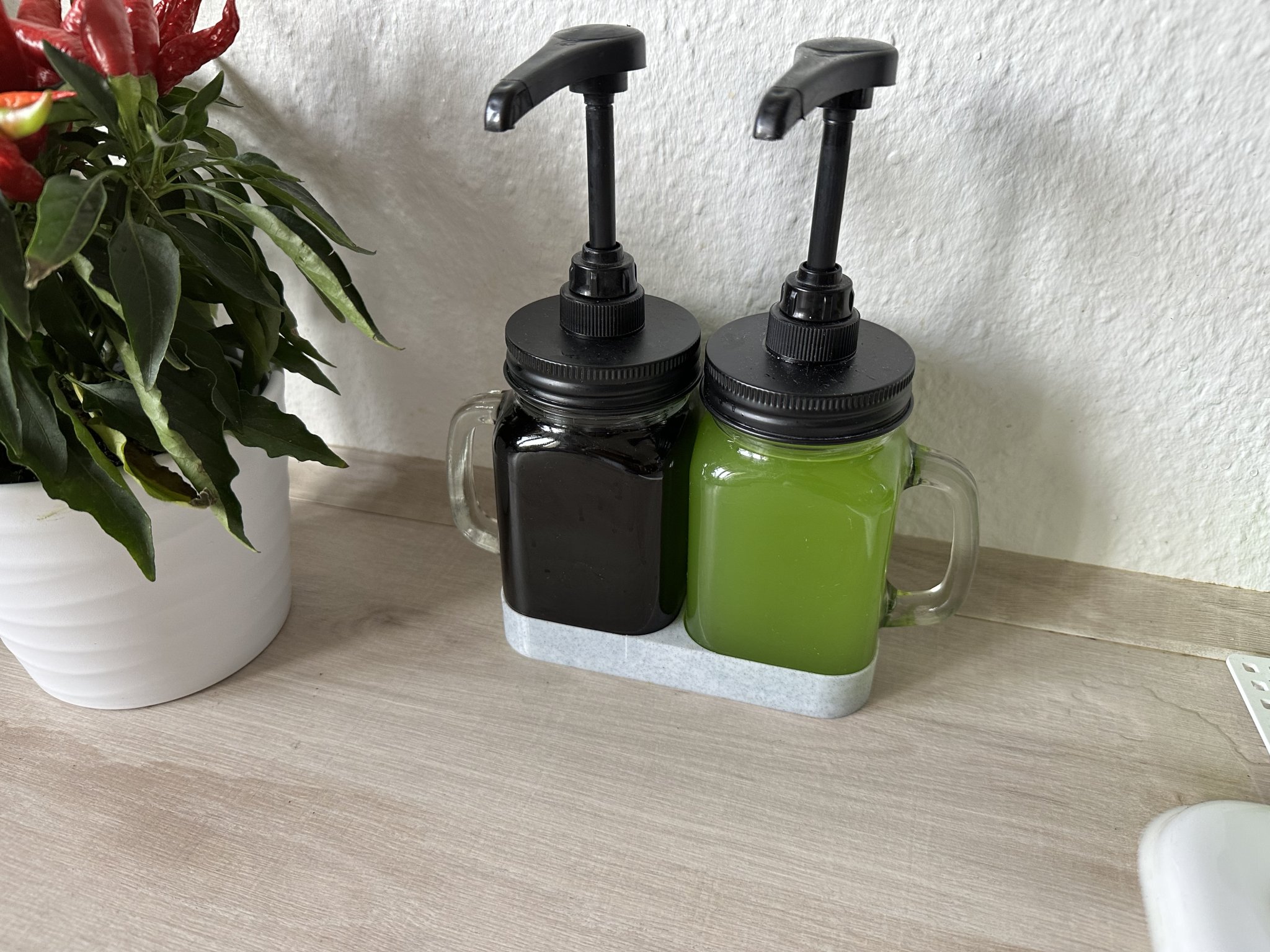 Giá đỡ giữ chặt bình siro gọn gàng trên bàn bếp