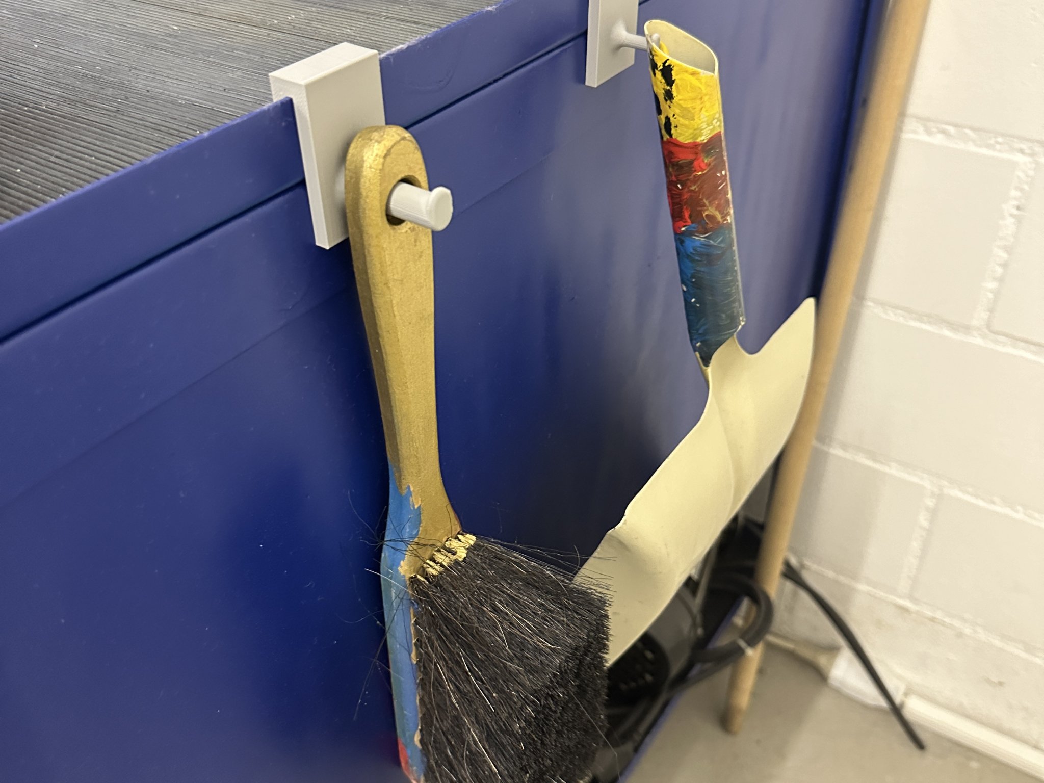 Giá đỡ chổi và xẻng tay treo trên xe đẩy trong xưởng