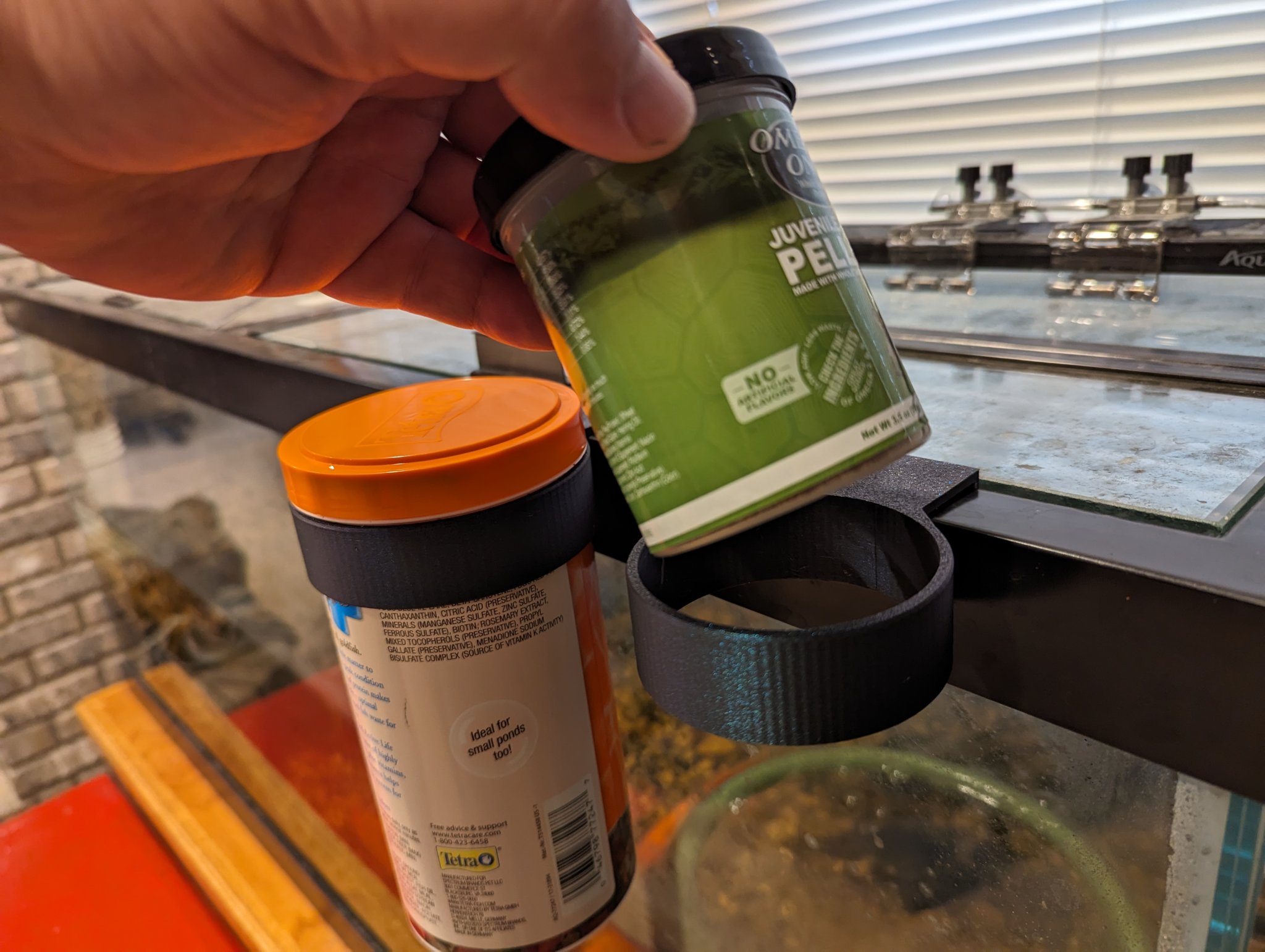 Giá đỡ thức ăn cho cá và rùa treo cạnh bể cá