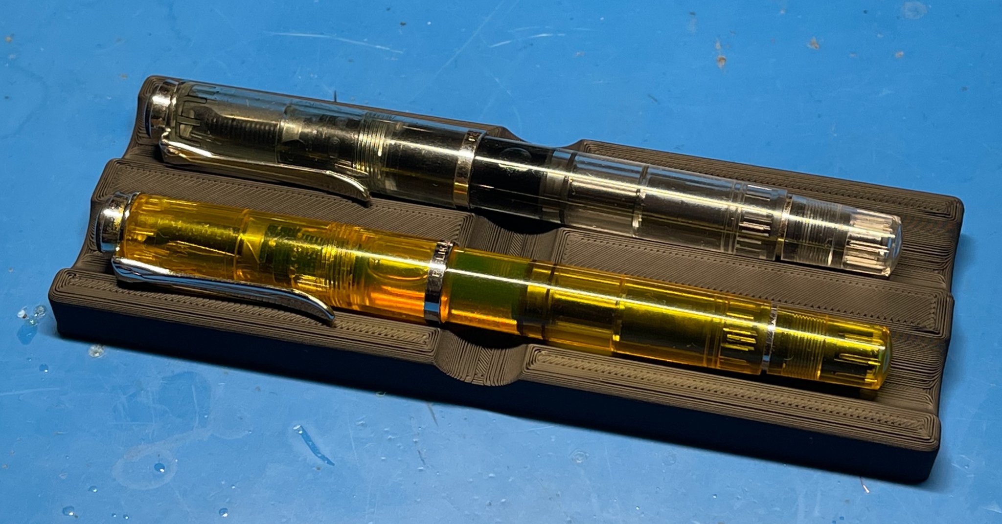 Khay để hai bút mực trên bàn làm việc