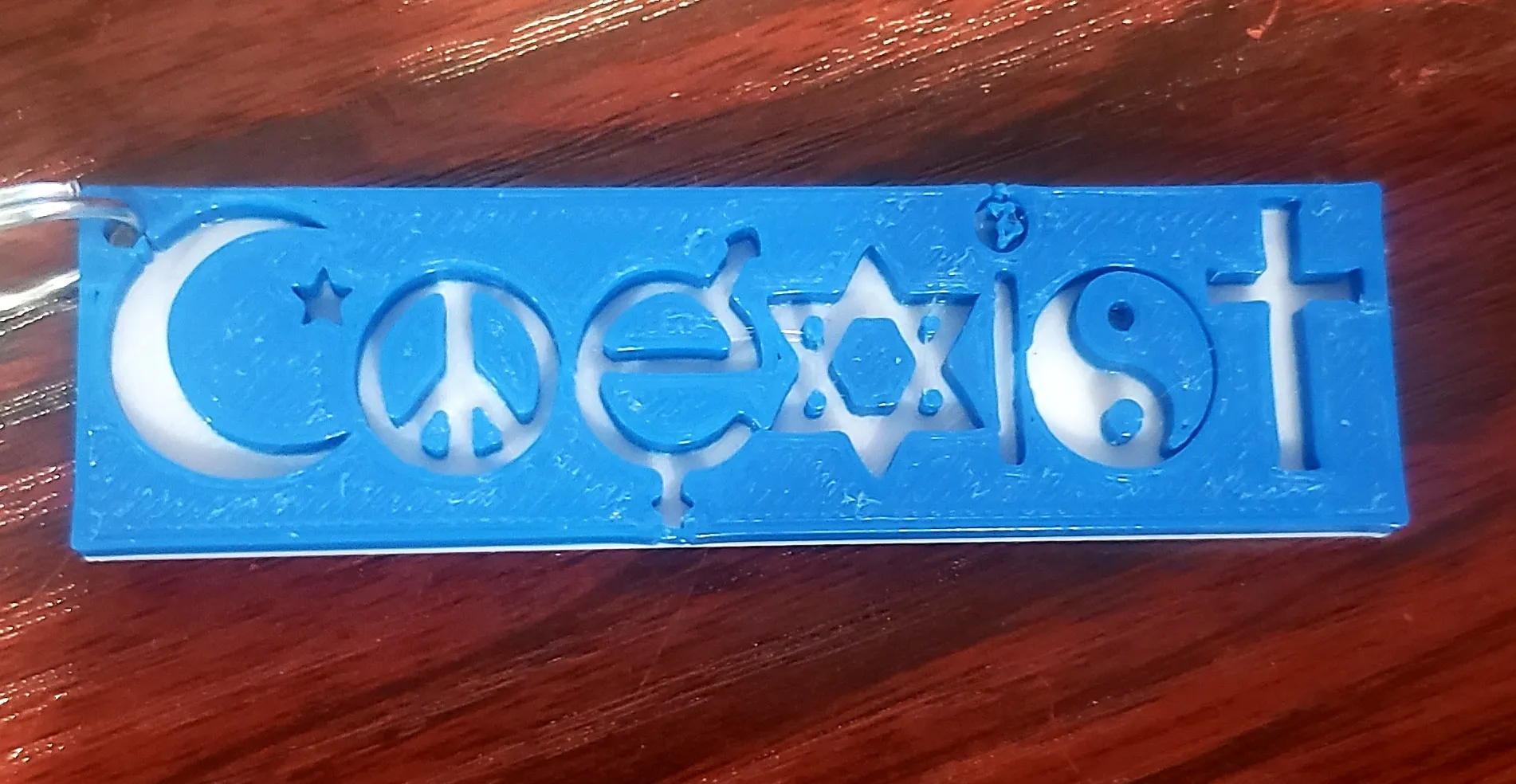 Móc khóa "Coexist" với hình ảnh tôn giáo