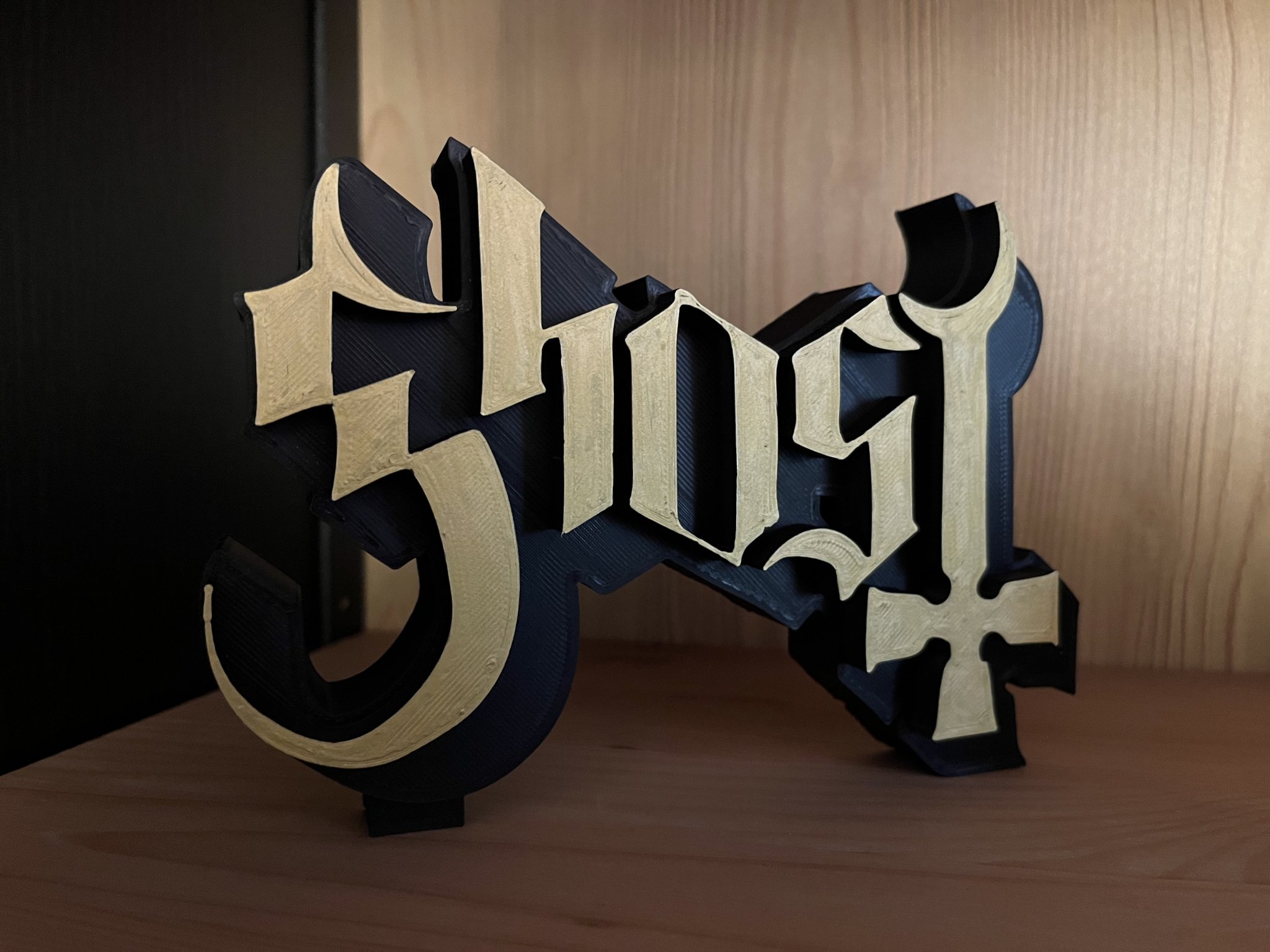 Biểu tượng Ghost B.C. in đen mờ với chữ vàng nổi bật