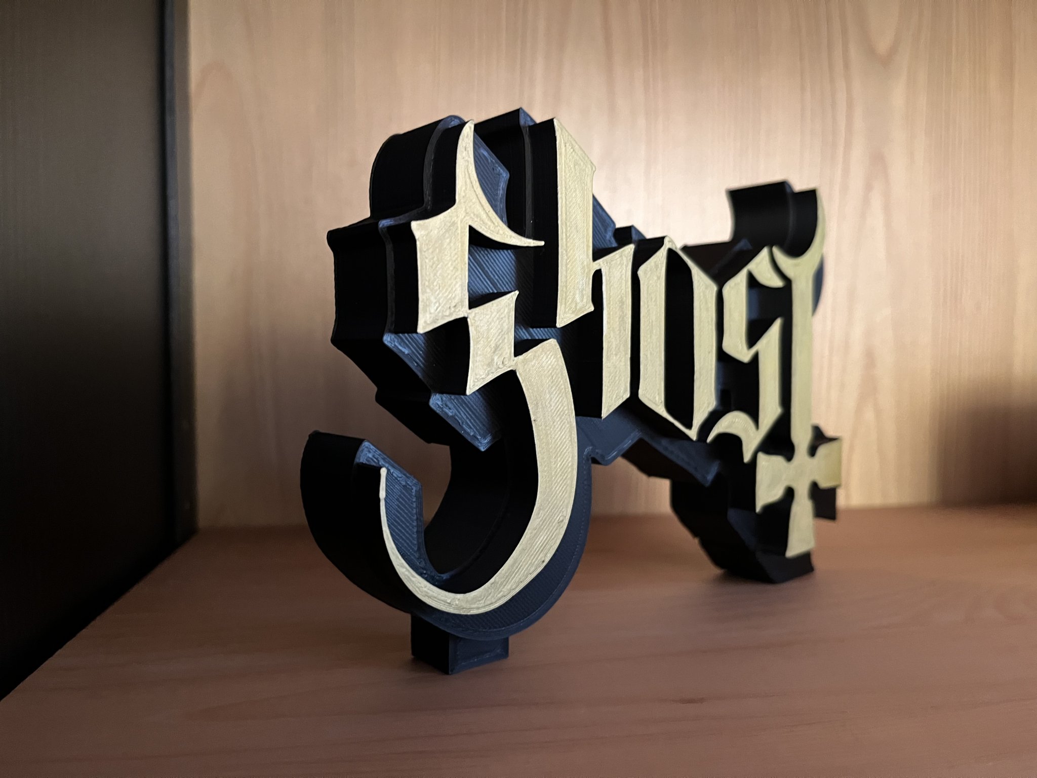 Biểu tượng Ghost B.C. in đen mờ với chữ vàng nổi bật