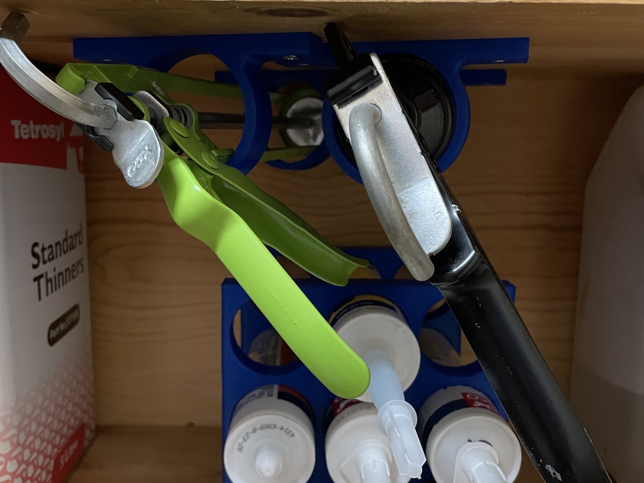 Giá đỡ súng bơm keo gắn kệ